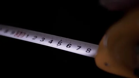 Measuring Tape Being Retracted in Slow Motion on Black Background Stock Footage 332664013