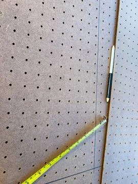 Measuring tape on pegboard wall in workshop or studio Stock Photos
