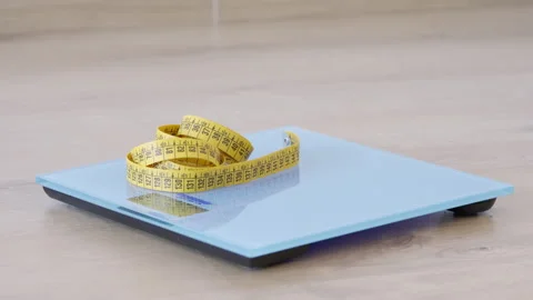 Measuring tape thrown on the blue scale Vidéo 265102960