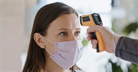 Measuring Temperature of a Young Female During Coronavirus Outbreak. Stock Footage 127315857