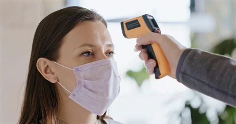 Measuring Temperature of a Young Female During Coronavirus Outbreak. Video stock 127316843
