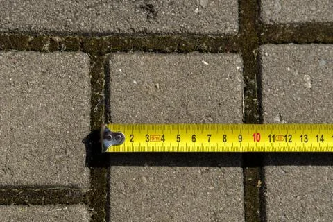 Measuring the tile width with a tape measure. Stock Photos