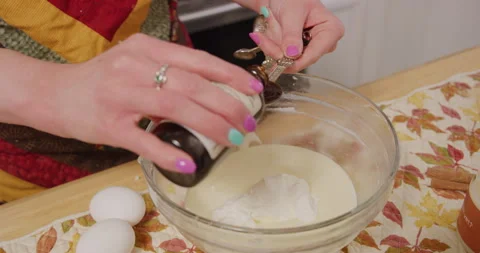 Measuring vanilla extract and pouring into mixing bowl Stock Footage 249349827