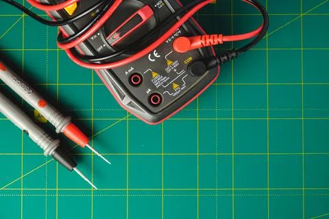 Measuring voltage with precision tools on a green cutting mat Stock Photos