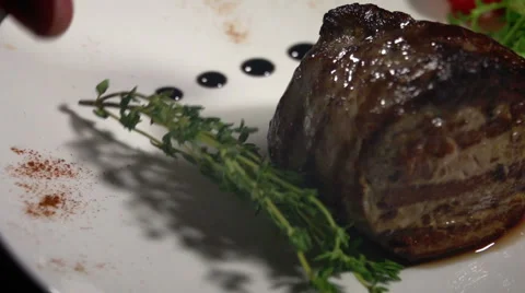 Meat and a sprig of thyme on a white plate Stock Footage 65388328