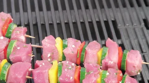 Meat and vegetable kebabs being placed on a grill Video stock 24656756