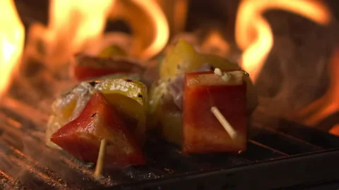 Meat and vegetable skewer roasting on grill with fire in slow motion Stock Footage 157842914