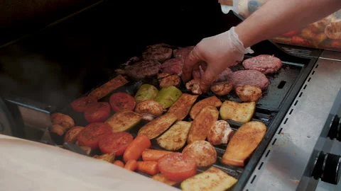 Meat and vegetables are cooked on a grill. Preparation of delicious shish Stock Footage 157370396