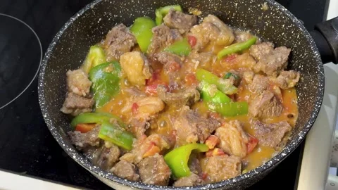 Meat and vegetables boiling in pan, close view of homemade stew cooking on stove Stock Footage 344833323