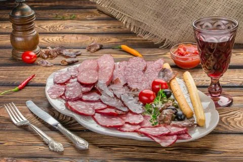 Meat appetizer selection. Salami, prosciutto, bread sticks, olives and sun-dr Stock Photos