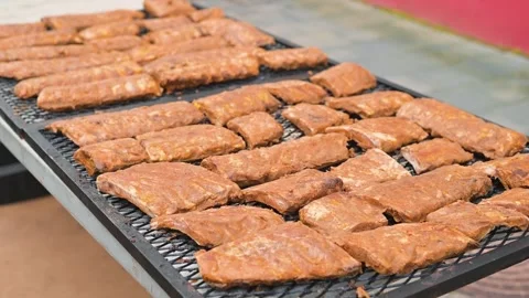 Meat is arranged on large trays, cooked and ready for serving. The setting Stock Footage 345885409