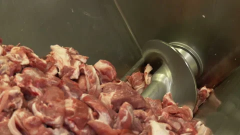 Meat is being chopped in a grinder. Big pieces of meat at a factory, close up. Stock Footage 144252643