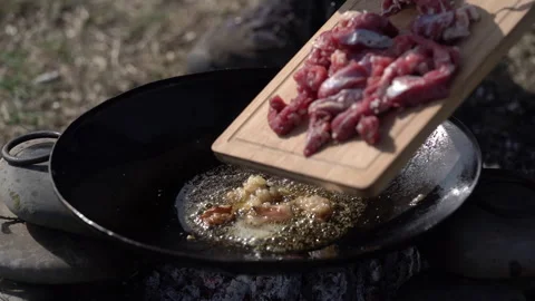 Meat Being Placed onto Pan Over Fire Video stock 327079870
