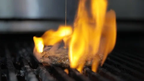 Meat Burger on Fire in the Grill With Gorgonzola Cheese Sauce on the Burger Stock Footage 128463582