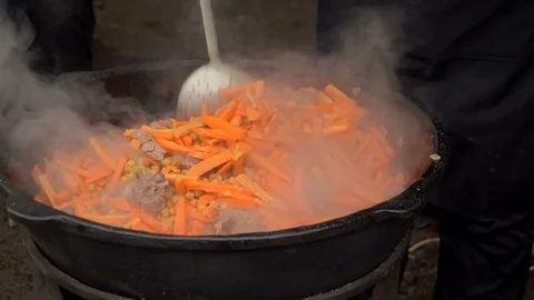 Meat, carrots and corn are cooked in a large saucepan. Video stock 84580040