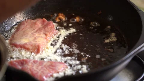 Meat chops in batter are placed in a hot frying pan. Meat is fried in oil 库存影片 182005231