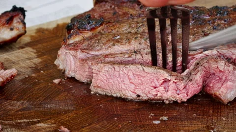 The meat is cut with a knife, the steak is cooked on the grill. Stock Footage 250442562
