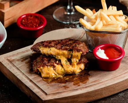 Meat cutlet with cheese inside and french fries Stock Photos