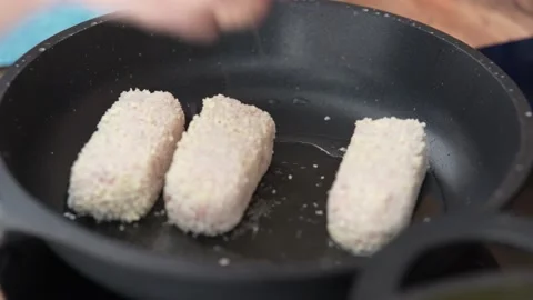 Meat cutlets are fried in pan. Chicken cutlets are fried in a black frying pan. Video stock 218324007