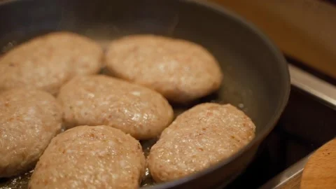 Meat cutlets being fried in a pan, close-up in slow motion Stock Footage 313170908