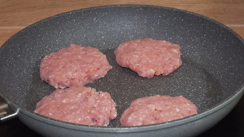 Meat cutlets being put on the pan by woman's hand Stock Footage 84197470