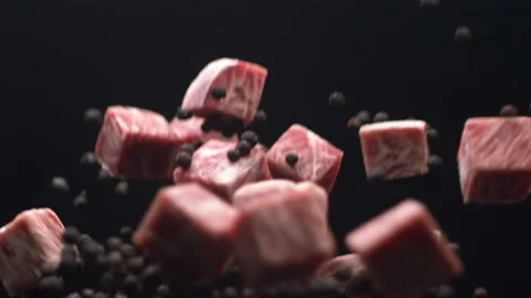 Meat cuts pieces flying up with black peppercorn in slow motion Stock Footage 157842979