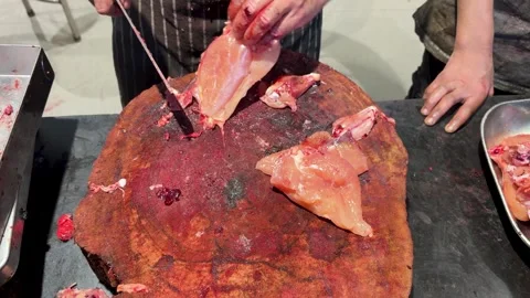 Meat cutting process with raw chicken and cleaver on wooden block Stock Footage 332912700