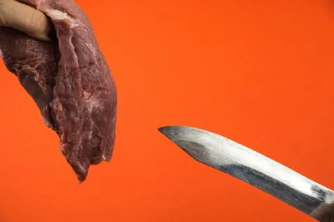 Meat cutting theme Large kitchen knife and a piece of raw fatty pork meat bef Stock Photos