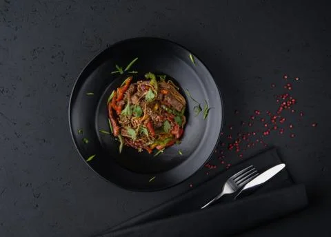 A meat dish on a black surface Stock Photos