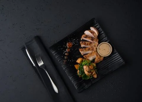A meat dish on a black surface Stock Photos