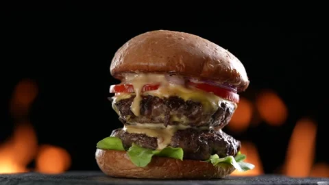 Meat double cheeseburger with vegetables on turntable on flaming background. Stock Footage 170319662