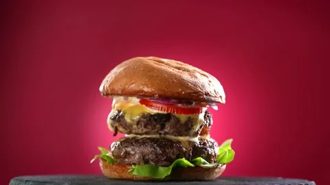 Meat double cheeseburger with vegetables on turntable on red background. Video stock 170320287