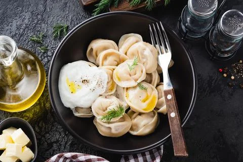 Meat dumplings, pelmeni served with butter and sour cream Stock Photos