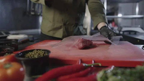 The meat falls on the cutting board, and the cook hits it. Stock Footage 231430902