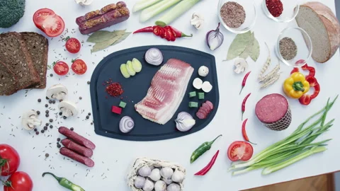 Meat with fresh vegetables lying on chopping board on table Stock Footage 233005117
