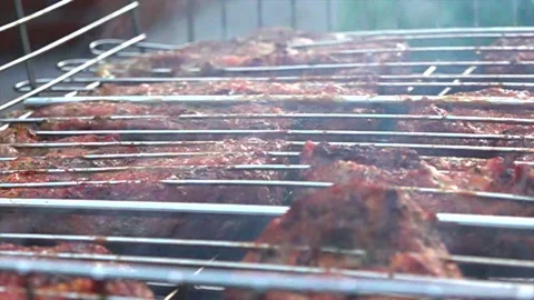 Meat is fried on a bbq in the garden Stock Footage 131502389