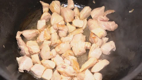 Meat is fried in a frying pan, turned over with a spatula. Stock Footage 248439710