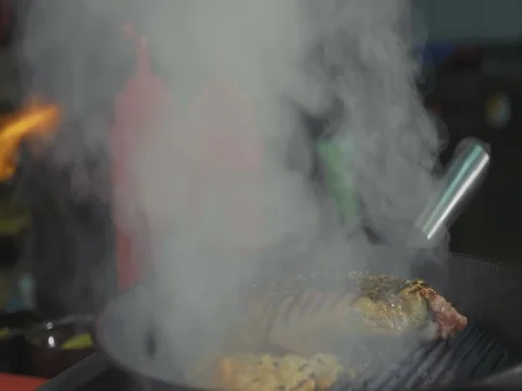 Meat frying on griddle pan. Closeup preparing steak at restaurant, slow motion Stock Footage 82842781