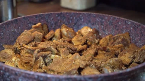 Meat gets cooked in a violet pan with steam coming up closeup Stock Footage 141037885