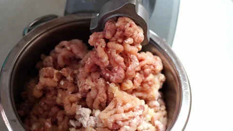 Meat grinder grinds minced meat into a large metal pan Stock Footage 281570957