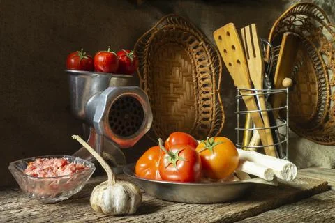 Meat grinder with vegetables on the background of kitchen utensils Stock Photos