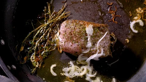 Meat ham steak grill on a pan with onion olive oil garlic and thyme pov Stock Footage 94264122