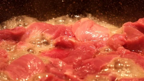 Meat with a high moisture content is fried in a frying pan and in the process Stock Footage 87503956