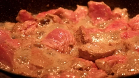 Meat with a high moisture content is fried in a frying pan and in the process Stock Footage 87504038