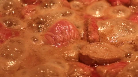 Meat with a high moisture content is fried in a frying pan and in the process Stock Footage 87504092