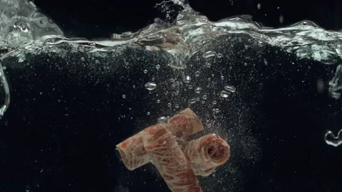 Meat for hotpot falling in slow motion in boiling water Stock Footage 157843021