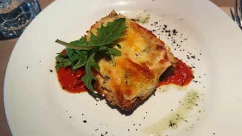 Meat lasagna with arugula leaf on the top. Slice of lasagna italian food pasta Stock Footage 297772378