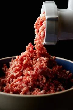 Meat Mincing process with electric meat grinder Stock Photos