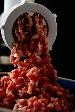 Meat Mincing process with electric meat grinder Stock Photos