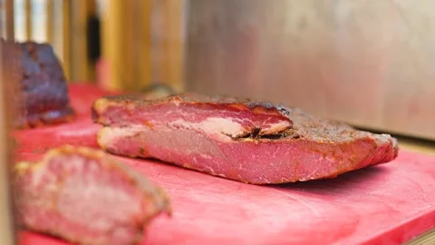 Meat is placed on a cutting board in a kitchen setting, showing the texture and Stock Footage 345884034